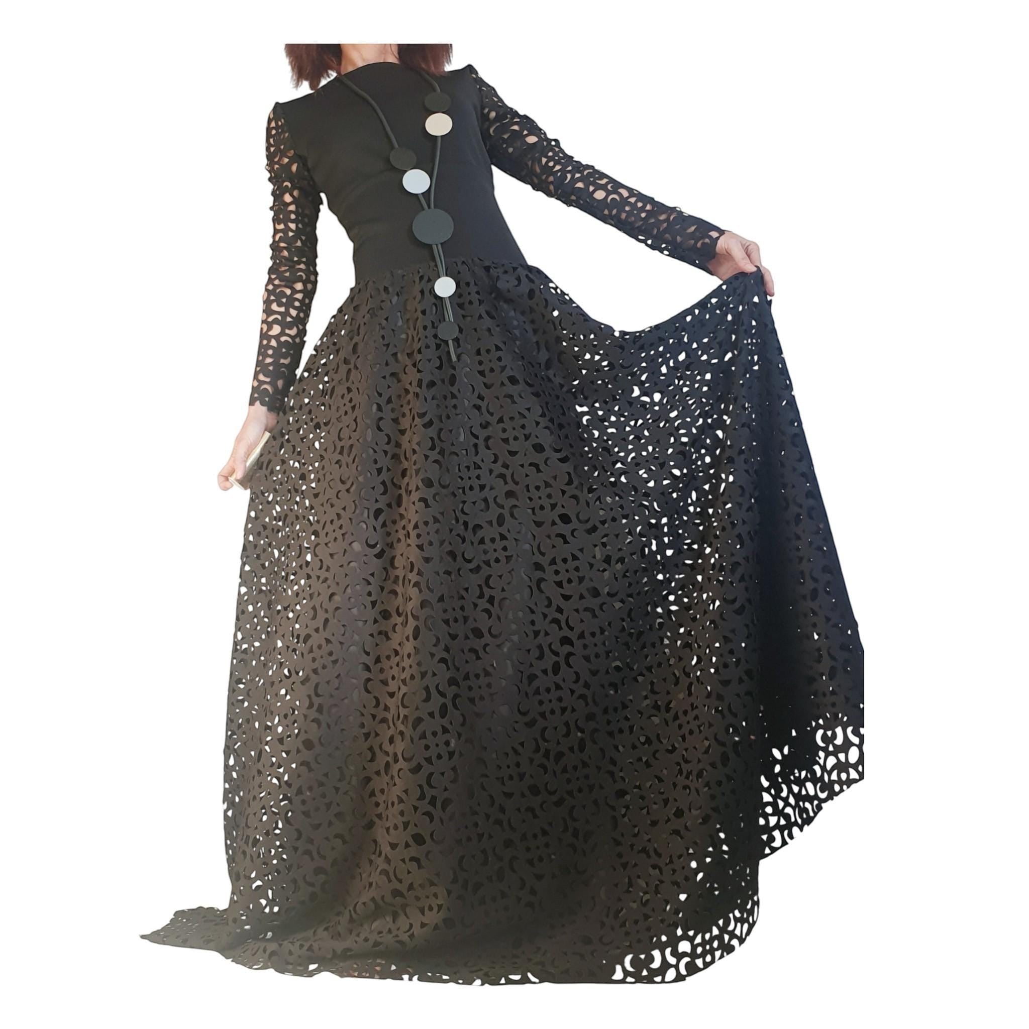 dreSSShoescode black polyester neoprene maxi skirt dress with intricate cut-out details and a statement necklace.